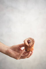 Hand holding a cruffin. Cruffins in the hands of man. Artisan pastry.