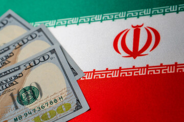 Iran national flag and the dollar bills. Business and finance concept, soft focus