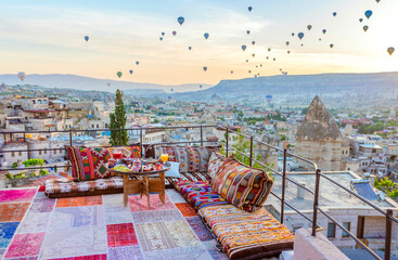 Traditional turkish breakfast with Cappadocia view and flying balloons on the background. Goreme, Turkey..