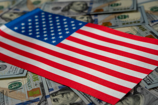 USA Flag with US dollars as background. Concept for investors, soft focus