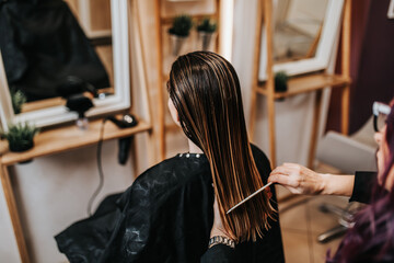 Beautiful young woman preparing for haircut at a beauty salon.