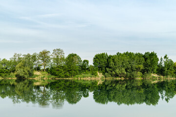 Fototapeta na wymiar Reflection of green trees in water surface of lake called Zelena voda in Slovakia.