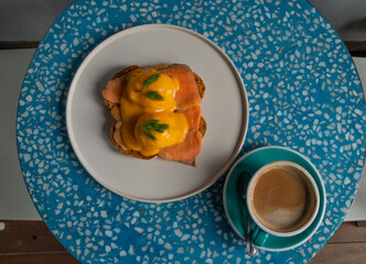 Delicious eggs Benedict with smoked salmon, hollandaise sauce and parsley.