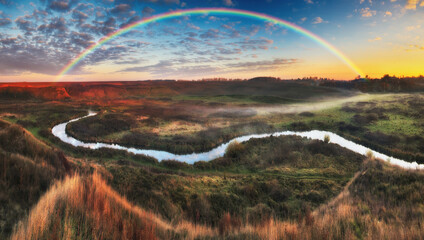 Amazing rainbow over the small rural river. autumn morning
