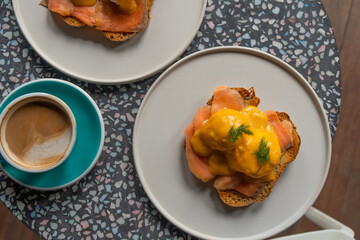 Delicious eggs Benedict with smoked salmon, hollandaise sauce and parsley.