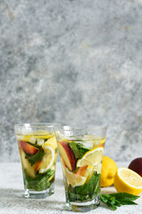 Lemonade with peach and mint in a glass cup on a concrete background. Peach lemonade.
