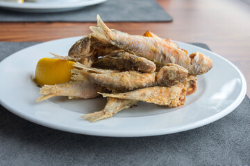 Crispy fried fish on a white background. Tasty mullus in a restaurant in Odessa. Traveling in Ukraine.