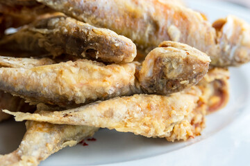 Crispy fried fish on a white background. Tasty mullus in a restaurant in Odessa. Traveling in...