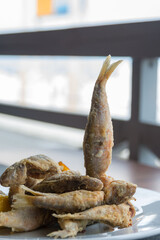 Crispy fried fish on a white background. Tasty mullus in a restaurant in Odessa. Traveling in...