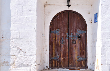 Old wooden door in a stone wall. The ancient entrance to the castle. Red gate