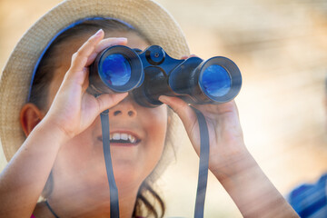 Young girl using binoculars mesmerized by national park landscape