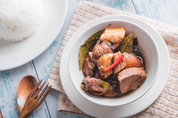 Pork Adobo (Flat lay) is a Filipino dish stewed in vinegar, garlic, onion,  soy sauce, bay leaves, peppercorns .