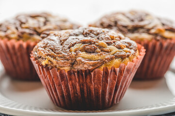 Freshly Baked Banana Chocolate Walnut Muffin on White Plate- Side View