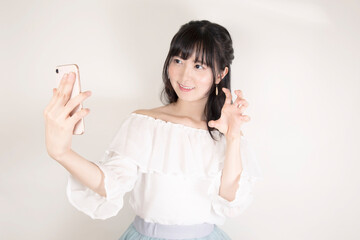 スマートフォンで自撮りする若い女性
