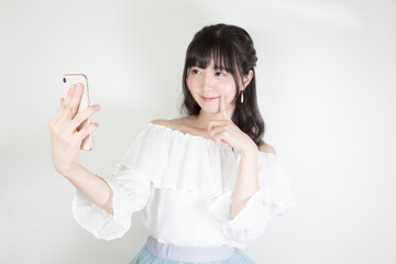 スマートフォンで自撮りする若い女性
