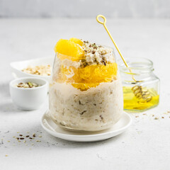 Tangerine oatmeal honey  breakfast in glass. Slective focus, copy space.