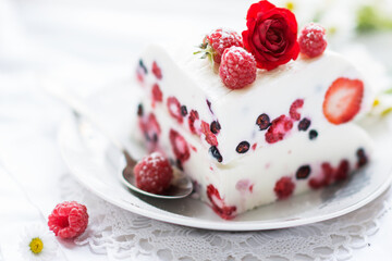 Dessert of yogurt , berries and gelatin, decorated with raw raspberries and natural red rose in white background, fresh, healthy food  