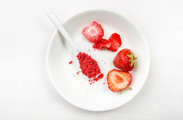 Strawberry powder made of freeze dried strawberries for sprinkle. Flavor and color ingredient for food. Top view, white minimal background, copy space. Great source of vitamin C and iron.