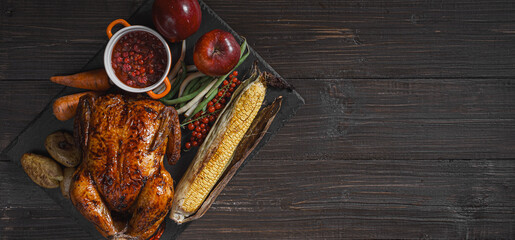 baked chicken and baked corn. family dinner table. baked chicken and vegetables with glasses of cider. delicious rustic dinner