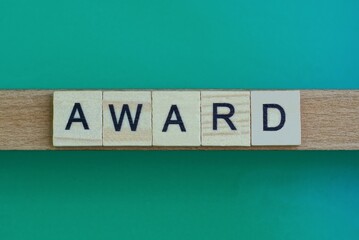 Obraz premium gray word award made of wooden square letters on green background