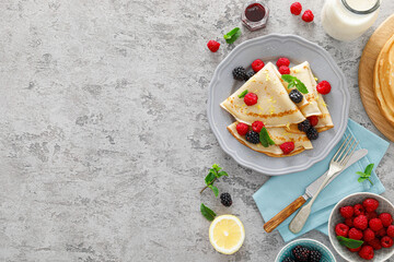 Thin crepes with fresh berries and lemon zest. Pancakes with raspberry and blackberry.