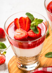 Cheesecake in the glasses with fresh strawberry.