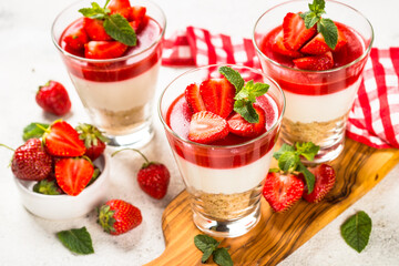 Cheesecake in the glasses with fresh strawberry.
