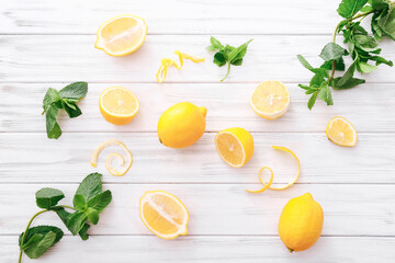 Fresh lemons and mint leaves on white wooden background. Flat lay. Fresh citrus fruit background.