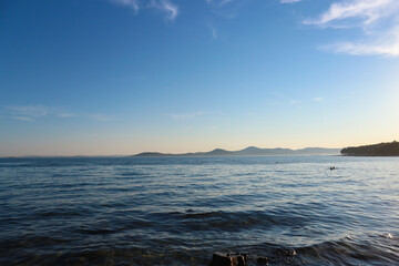 Magnificent blue environment of dalmatian coast, with rows of islands on the horizon, lit by sunset sun