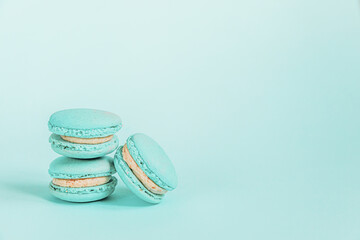 Sweet almond colorful unicorn blue macaron or macaroon dessert cake isolated on trendy blue pastel background. French sweet cookie. Minimal food bakery concept Copy space
