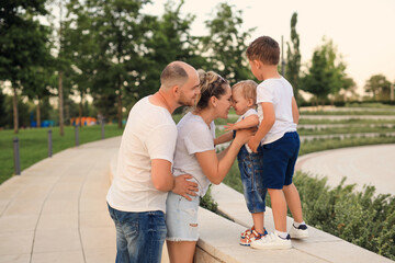 Fototapeta premium Family summer leisure in the park. mom dad and two sons have fun and play.