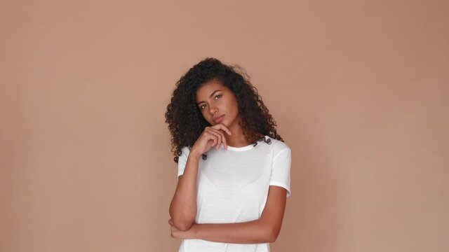 young black woman thinking looking on the sides and wondering on brown studio background