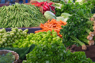 Variety of colorful fresh organic vegetables and greenery on the farmers market stall, homegrown natural eco food, carrot, green peas, pepper, cabbage, parsley, squash