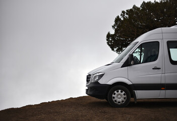 Comfortable minibus on mountain peak in fog