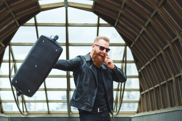 Stylishly dressed young man with a beard learns the good stunning news by phone. Lifestyle...