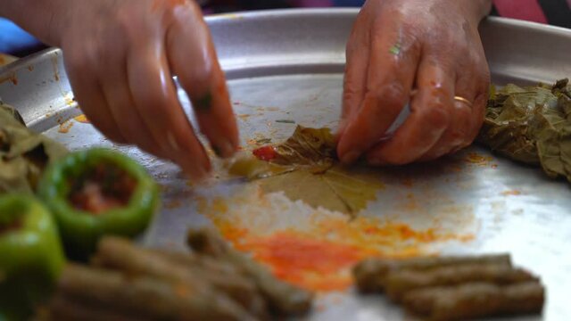 A woman is preparing stuffed grape leaves, leaf wrap, Turkish food culture and stuffed leaves