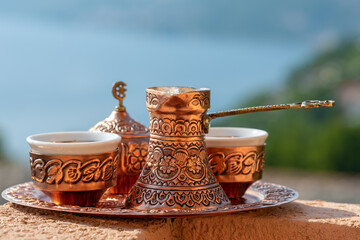 Traditional black bosnian coffee in beautiful copper cezve at wooden table