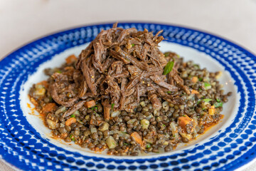 shredded meat with beans and stewed vegetables on a plate