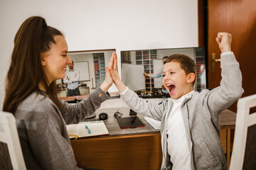 Obraz premium Boy and girl studies at home and doing school homework. Distance learning online education.