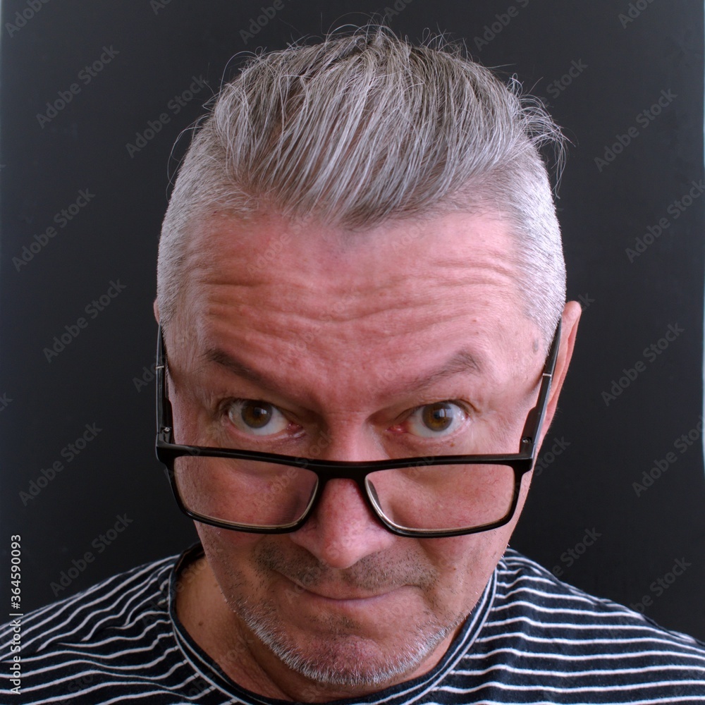 Wall mural middle-aged man with glasses looks surprised