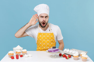 Shocked male chef or cook baker man in apron white t-shirt toque chefs hat cooking at table...