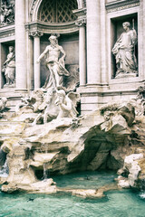Side view of the statues of the Trevi Fountain in Rome. Italy. Vertically. Edited as a vintage photo.