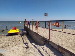 Obraz premium Yellow red catamaran near the pier on the beach