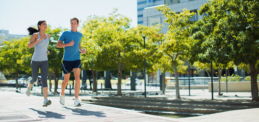 Obraz premium Couple jogging on urban sidewalk