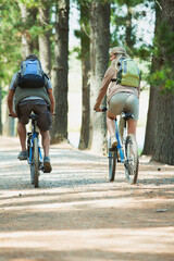 Obraz premium Couple mountain biking with backpacks in woods