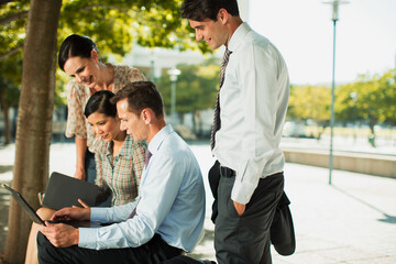 Obraz premium Business people using laptop in urban park