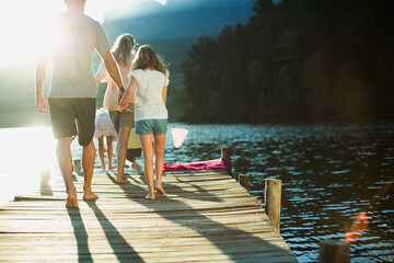 Family walking on dock over lake