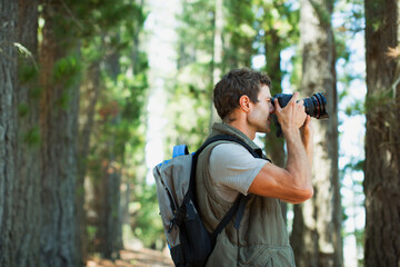 Man using digital camera in woods