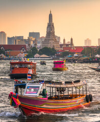Fototapeta na wymiar Boats on Chao Phraya River and Wat Arun, The Temple of Dawn, an Important Buddhist Temple and a Famous Tourist Destination in Bangkok Yai District of Bangkok, Thailand.