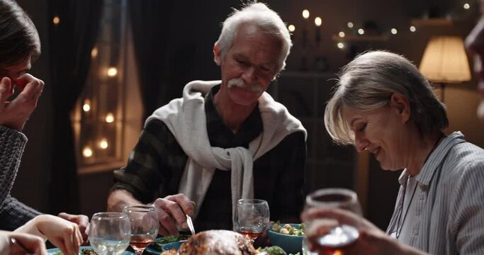 Happy large caucasian family of different generations celebrating christmas at home. People having a dinner xmas party eating, talking and smiling 4k footage